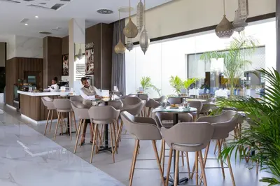 a restaurant with a man sitting at a bar at Hotel Riu Palace Boavista - All Inclusive in Boa Ventura
