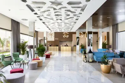 a lobby with couches and chairs in a building at Hotel Riu Palace Boavista - All Inclusive in Boa Ventura
