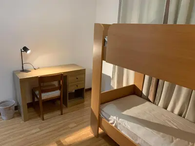 a bedroom with a desk and a bunk bed with a desk at Kaza Awa - Urban Guesthouse in Praia