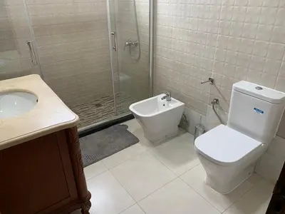 a bathroom with a shower and a toilet and a sink at Kaza Awa - Urban Guesthouse in Praia