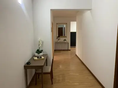 a hallway with a table and a white wall at Kaza Awa - Urban Guesthouse in Praia