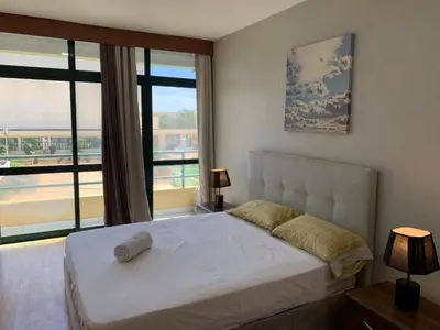 a bedroom with a white bed and a large window at Kaza Awa - Urban Guesthouse in Praia