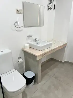 a bathroom with a sink and a toilet and a mirror at Apartamento Baia Marginal 2 in Mindelo