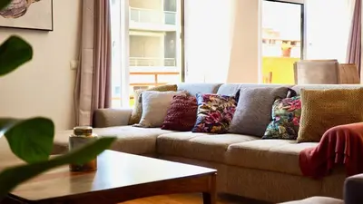 a living room with a couch with pillows on it at Spacious Penthouse with BBQ and Views in Praia