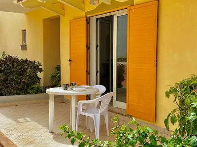 a white table and two chairs on a patio at Raio Do Sol - Beach front studio with city view in Santa Maria