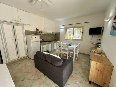 a living room with a couch and a kitchen with a table at Raio Do Sol - Beach front studio with city view in Santa Maria