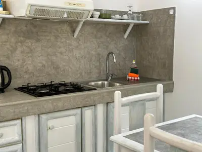 a kitchen with a sink and a stove at Raio Do Sol - Beach front studio with city view in Santa Maria