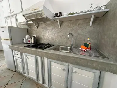 a kitchen with a sink and a stove at Raio Do Sol - Beach front studio with city view in Santa Maria
