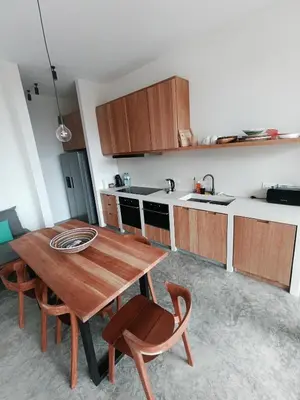 a kitchen with a wooden table and some chairs at São Pedro Bay in Mindelo