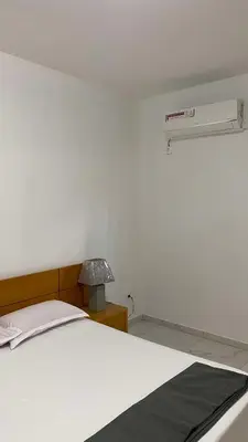 a white bedroom with a bed and a lamp at Apartamento Casa Sabi in Praia
