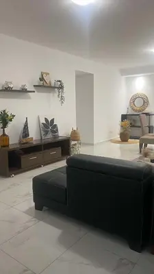 a living room with a black couch in a room at Apartamento Casa Sabi in Praia