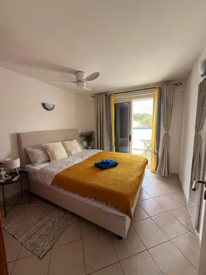a bedroom with a bed with a yellow blanket at Leme Bedje - Two bedroom, Pool, WiFi & Beachfront in Santa Maria