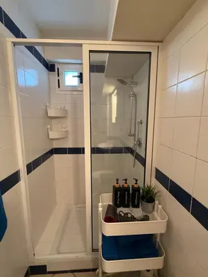 a bathroom with a shower and a sink with bottles at Leme Bedje - Two bedroom, Pool, WiFi & Beachfront in Santa Maria
