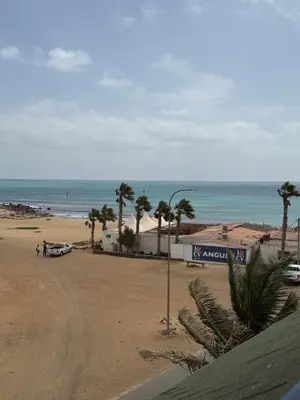 a view of a beach with palm trees and the ocean at Leme Bedje - Two bedroom, Pool, WiFi & Beachfront in Santa Maria