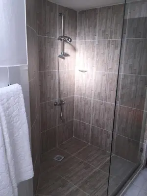 a shower with a glass door in a bathroom at Bed and breakfast Residencial Maravilha in Mindelo