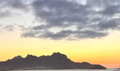a sunset with a mountain in the background at Bed and breakfast Residencial Maravilha in Mindelo