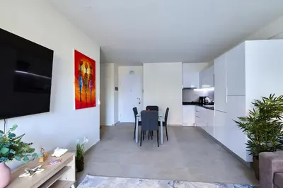 a living room with a table and a kitchen at Apartamentos Golfinho Dourado `Edifício Lux,s in Santa Maria