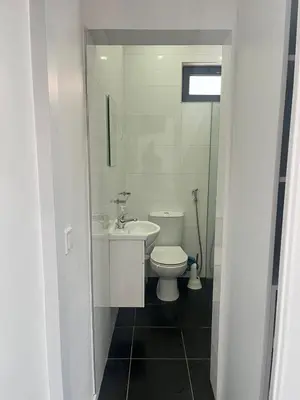 a bathroom with a white toilet and a sink at Apto Duarte quarto no terraço in Praia