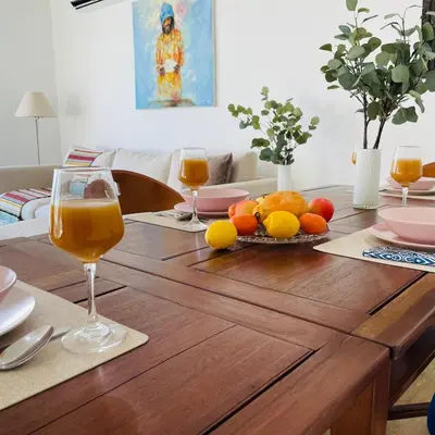 a table with two glasses of orange juice and fruit on it at Sal Little Heart Grand Terrace Apartment 26 in Santa Maria