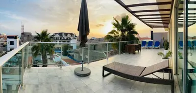 a balcony with a bench and an umbrella on a building at Sal Little Heart Grand Terrace Apartment 26 in Santa Maria