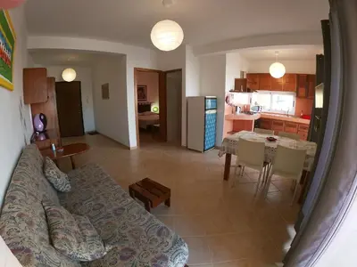 a living room and kitchen with a couch and a table at Casa Bahia 4 in Santa Maria