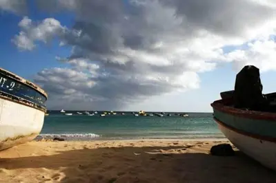 two boats sitting on a beach with the ocean at Casa Bahia 4 in Santa Maria