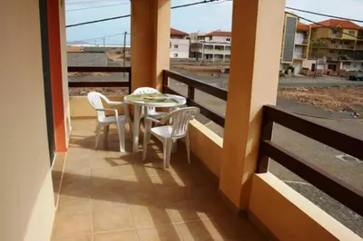 a patio with a table and chairs on a balcony at Casa Bahia 4 in Santa Maria