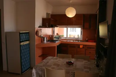 a kitchen with a table and chairs and a refrigerator at Casa Bahia 4 in Santa Maria