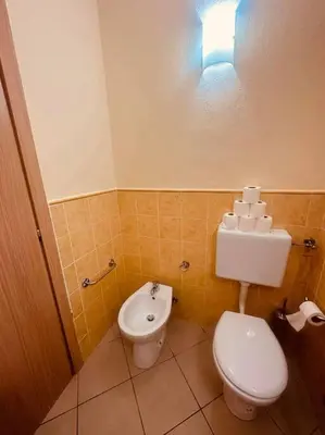 a bathroom with a toilet and a bidet and a light at appartement by seb in Santa Maria