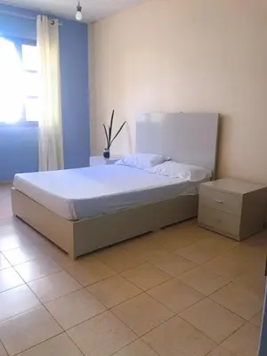 a bedroom with a large white bed with a night stand at Conforto no Coração do Tarrafal in Tarrafal