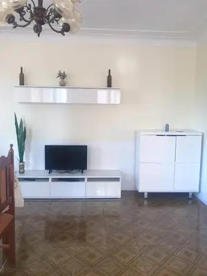 a living room with a tv on a white wall at Conforto no Coração do Tarrafal in Tarrafal