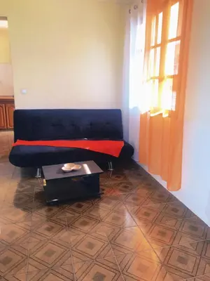 a living room with a blue couch and a coffee table at Conforto no Coração do Tarrafal in Tarrafal