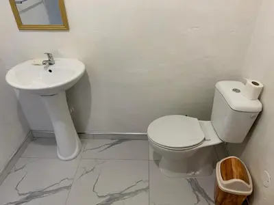 a white bathroom with a toilet and a sink at TCHAN LOVe in Portela