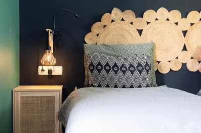 a bedroom with a bed with a large headboard at Casa Archipel - Lagedos in Ribeira Fria