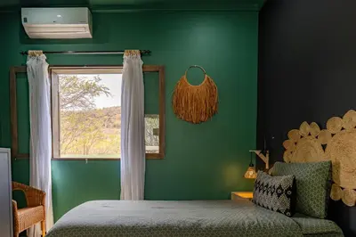 a green bedroom with a bed and a window at Casa Archipel - Lagedos in Ribeira Fria