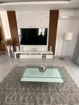a living room with a tv and a glass table at Felicidade apartamento Palmarejo Grande in Praia