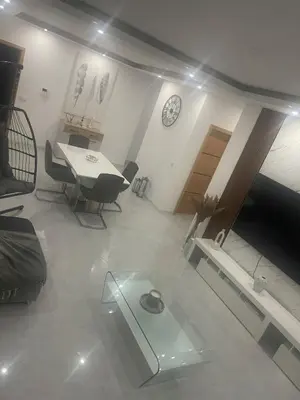 a living room with a table and a clock on the wall at Felicidade apartamento Palmarejo Grande in Praia
