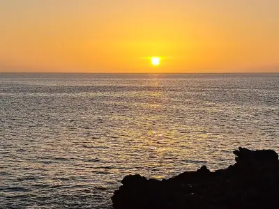 a sunset over the ocean with the sun setting at Barros Homestay in Tarrafal