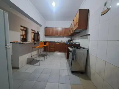 a kitchen with wooden cabinets and a stove at Barros Homestay in Tarrafal