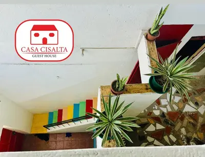 a sign on a wall with potted plants on it at Casa Cisalta N4 - Quarto Compartilhado in Praia