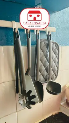 a rack of cooking utensils hanging on a wall at Casa Cisalta N4 - Quarto Compartilhado in Praia