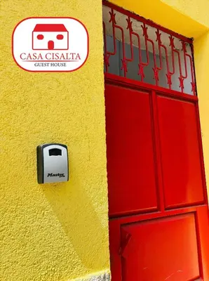 a red door with a sign on a yellow wall at Casa Cisalta N5 - Quarto Casal in Praia