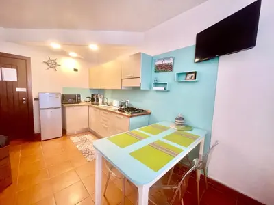 a small kitchen with a table and a refrigerator at Porto Antigo 2 studio 15 beach and pool in Santa Maria