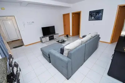 a living room with a couch and a tv at Apartment 3 minutes from Nelson Mandela Airport in Praia