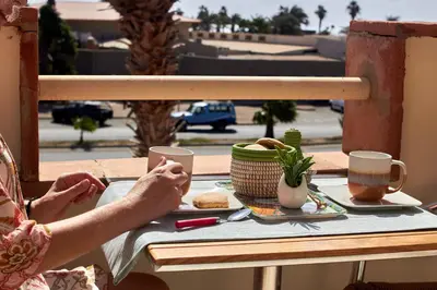 a person sitting at a table with a plate of food at Paraiso Tropical wifi and pool Djadsal moradias in Santa Maria