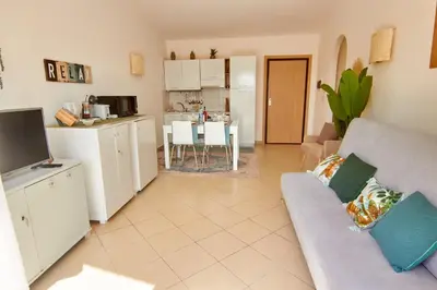 a living room with a couch and a kitchen at Paraiso Tropical wifi and pool Djadsal moradias in Santa Maria