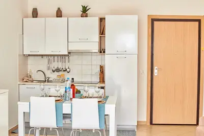 a kitchen with white cabinets and a table and chairs at Paraiso Tropical wifi and pool Djadsal moradias in Santa Maria