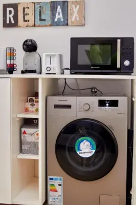 a washing machine in a shelf with a microwave at Paraiso Tropical wifi and pool Djadsal moradias in Santa Maria