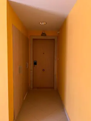 an empty hallway with a door in an orange room at Soares Appart's in Santa Maria