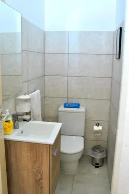 a small bathroom with a toilet and a sink at Tambarina Guest House in Mindelo